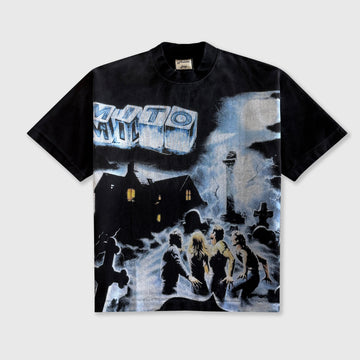A black short-sleeve graphic t-shirt featuring a large, detailed black and white print on the front depicting a snowy night scene with a house, figures, and a large sign reading 'MYTH'.
